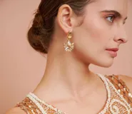 Aros colgantes con base rectangular y dije con forma de flor.