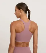 Top deportivo ajustado color malva, con escote halter y espalda nadador.