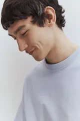 Remera celeste de punto de algodón pesado, corte holgado, cuello redondo ribeteado, hombros caídos y bajo recto.