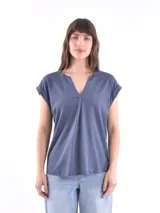 Blusa blanca de corte holgado, con cuello en V y mangas cortas.
