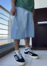 Bermuda de jean celeste, corte ancho y largo a la rodilla, con aplique de estrella en el lateral.