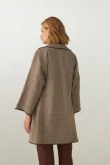 Tapado marrón de largo medio, abierto, con cuello y envivado. Hecho 100% en Uruguay con tela 100% lana fina sin teñir, diseñada exclusivamente por Don Baez.