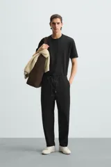 Pantalón verde militar de corte carrot fit, confeccionado en tejido de algodón. Cuenta con cintura elástica ajustable con cordón, bolsillos frontales y un bolsillo trasero de plastrón.