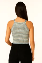 Musculosa cropped de acrílico calado, con breteles finos y cuello recto.