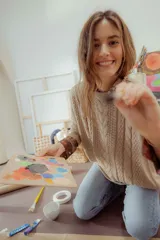 Buzo tejido en hilo de algodón color tostado, de corte holgado, con hombros caídos y diseño de ochos en la parte delantera.