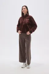 Buzo de polar tipo sherpa en color crudo, con cuello alto y cierre frontal parcial. Presenta un bolsillo de parche con cierre en el pecho y mangas largas de calce holgado.