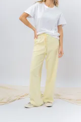 Pantalón jogger wide fit color amarillo pastel, confeccionado en algodón suave, con cintura elástica con cordón ajustable y bolsillos laterales funcionales.