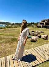 Conjunto de pantalón y cárdigan color manteca de tejido calado.