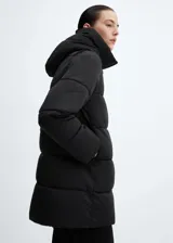 Campera puffer negra con capucha, cierre frontal con cremallera y bolsillos laterales con cierre.