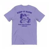 Remera lila de algodón con estampa en la espalda de un perro con gafas de sol y la frase "Keep It Slow. Fuck Fast Fashion. Emexem".