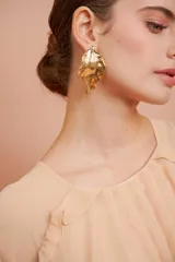 Aros colgantes con forma de hoja irregular dorada.