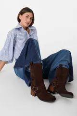 Bota corta negra de gamuza con caña baja doblada, puntera cuadrada y apliques metálicos plateados.