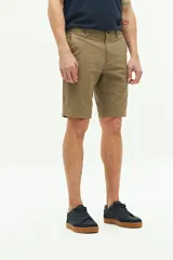 Bermuda de gabardina color verde militar, con bolsillos laterales y traseros, cierre con cremallera y botón, y trabillas para cinturón.