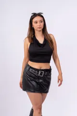 Minifalda negra de cuero sintético con cinturón con hebilla metálica cuadrada y ojales.