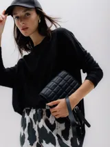 Sweater negro de punto acanalado con cuello redondo y manga larga.