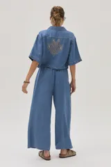Pantalón de jean celeste de corte ancho, con cintura alta y lazo ajustable.