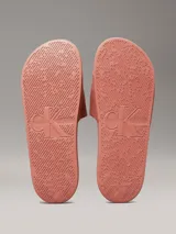 Ojotas color salmón con logo Calvin Klein Jeans en blanco.