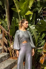 Pantalón plateado de lamé elastizado, corte palazzo y tiro alto.