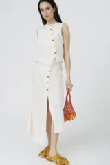 Top marrón de lino con cartera asimétrica y botones de madera. Tiene ojales bordados con frutitas.