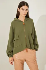 Campera de punto gris con capucha y cierre, de corte holgado y bolsillos frontales.