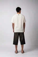 Remera color crudo de lino con textura entramada, calce cómodo y mangas cortas.