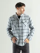 Camisa de franela a cuadros rojos, negros y grises, de manga larga y corte clásico, con dos bolsillos en el pecho.