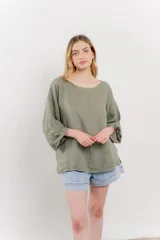 Blusa verde oliva de lino, de corte holgado, mangas 3/4 y cuello redondo.