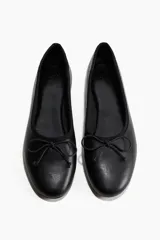 Ballerinas negras de cuero con punta redonda y moño.