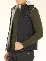 Chaleco verde militar de nylon mate reversible con interior de tejido jogging gris melange, con capucha y cierre frontal con cremallera.