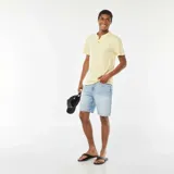 Camiseta amarilla de manga corta con cuello henley y tres botones.