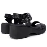 Sandalias negras con plataforma y suela track. Tiras anchas con textura símil cuero de cocodrilo y hebilla metálica ajustable en el tobillo.