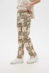 Pantalón de lino color verde oliva con estampado de flores color crema, de corte recto.