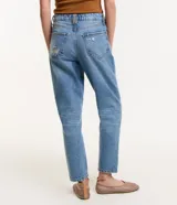Pantalón mom de jeans celeste con trabillas en la cintura, cierre con botón y cremallera, bolsillos y deshilachados.