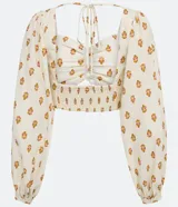 Blusa cropped de lino con escote corazón, lazada en la espalda, manga larga abullonada y estampado de anacardos.