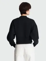 Sweatshirt negro Balmain Paris de corte cropped, con cuello alto y logo estampado en blanco. Presenta botones dorados en el hombro.