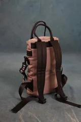 Matera estilo mochila color verde militar, confeccionada en nylon acolchado con detalles en símil cuero negro. Cuenta con tapa con cierre metálico, bolsillo interno, asas de mano y correa extensible para llevar al hombro o cruzada.