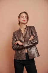 Chaqueta corta abierta de lentejuelas color cobre, con cuello mao y mangas largas.
