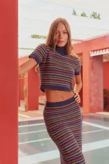 Remera tejida de cuello alto y manga corta con rayas horizontales en tonos lila, amarillo, naranja y rojo.