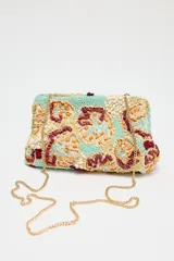 Bolso de mano tipo sobre con cuerpo cubierto de cuentas y abalorios en tonos celeste, beige, naranja y marrón. Tiene asa de cadena extraíble, bolsillo interior con cremallera y cierre con clip imantado y lazo.