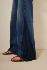 Pantalón de jean de tiro alto, corte wide leg, con diseño de parches en diferentes tonos de azul.