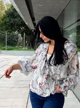 Blusa estampada con cuello en V, mangas largas abullonadas y corte a la cintura.