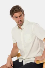 Camisa de hombre color crema, de manga corta, con cuello abotonado, corte clásico y bolsillo en el pecho. Confeccionada en algodón.