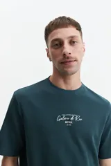 Remera marrón de manga corta con cuello redondo y estampado pequeño en el pecho.