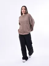 Sweater de punto color beige, de corte holgado y cuello redondo.