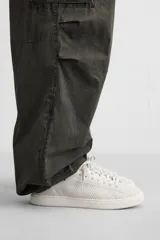 Zapatilla blanca de cordones fabricada en tejido transpirable de punto.