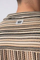 Camisa de manga corta con cuello solapa, corte holgado y estampado de rayas verticales en tonos beige, negro y rojo.