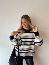 Sweater de punto con rayas horizontales en blanco y negro, cuello redondo y corte holgado.