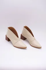 Botines color peltre de cuero con taco de madera y corte en V en el frente.