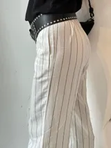 Pantalón sastrero a rayas verticales blancas y celestes.