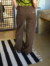 Pantalón de jean color óxido chocolate, de corte recto y tiro medio, con diseño de cinco bolsillos y botón metálico.